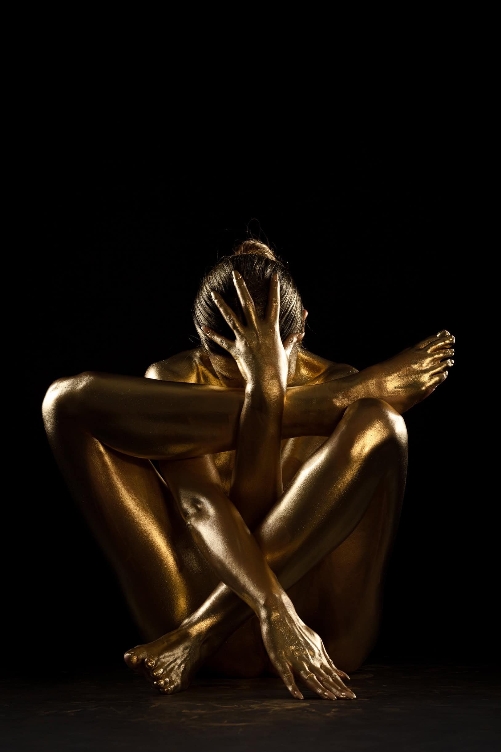 Gold Bodypainting im kreativen Prozess, kauernde Pose, Fotostudio Hamburg