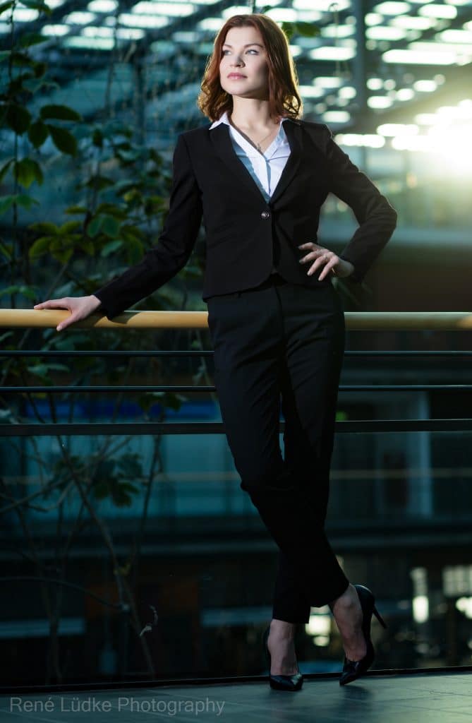 Business-Portrait einer Frau im schwarzen Anzug, fotografiert outdoor in moderner Architektur in Hamburg.