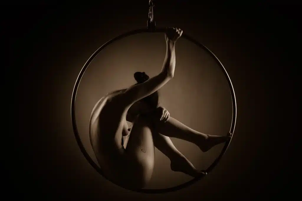 Künstlerisches Aktfoto einer Frau in einem Metallring – Fine Art Aktfotografie von René Lüdke, Hamburg.