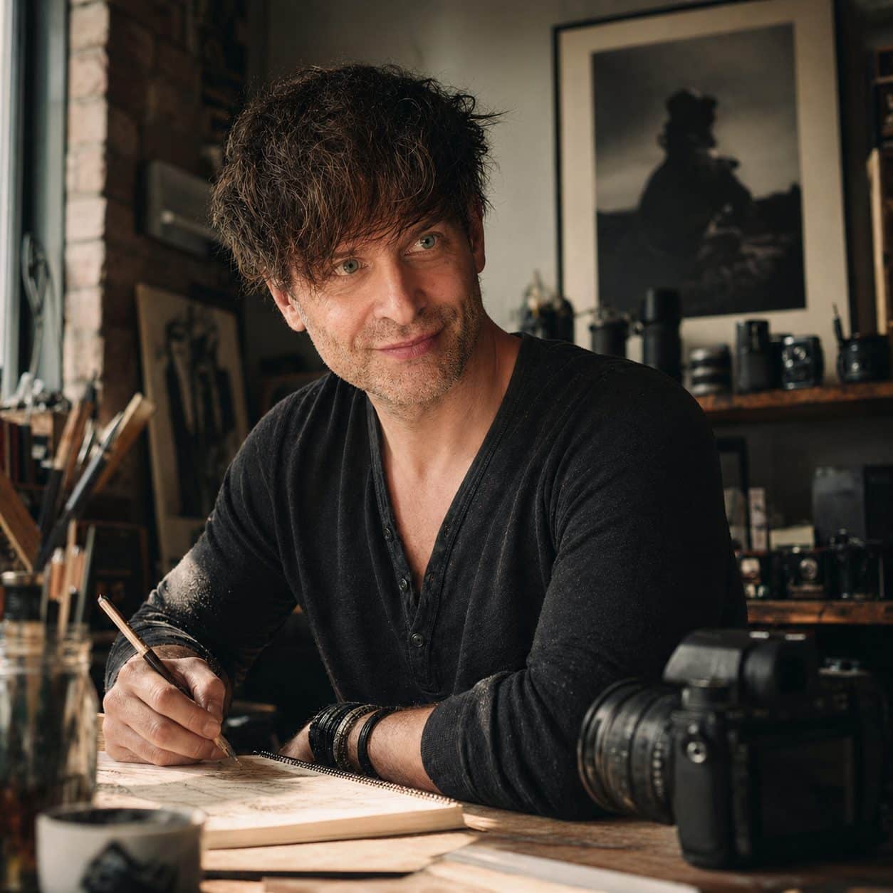 Porträt von René Lüdke, Boudoir- und Porträtfotograf aus Hamburg, am Schreibtisch im Atelier mit Kameraequipment