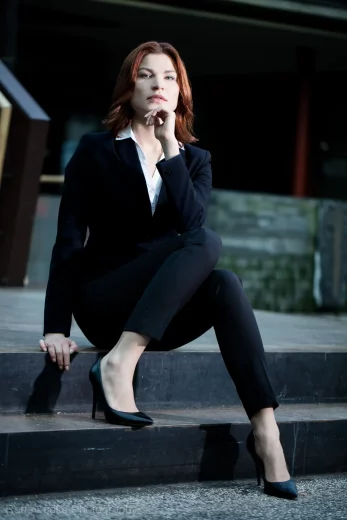 Businessportrait einer Frau in einem Anzug auf einer Treppe sitzend